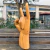 Escultura em madeira de mão fazendo sinal de "rock" com dedo indicador e mínimo levantados