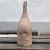 Escultura em cerâmica de um boto cor de rosa estilizado em tom marrom com acabamento fosco