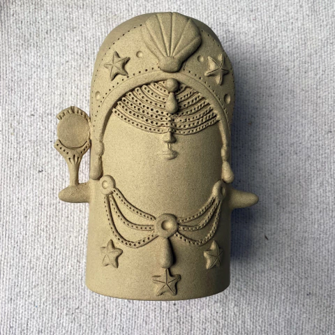 Escultura de Iemanjá em cerâmica, com detalhes em relevo e adornos, representando a deusa das águas.