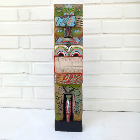 Escultura de madeira de Célio Souza colorida com detalhes artísticos, representando uma figura estilizada e simbólica 