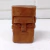 Escultura em madeira de uma cabeça pequena, com traços geométricos e detalhes minimalistas.