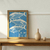 Quadro decorativo com estampa de peixes em fundo azul, com a frase "O mar começava todos os dias de novo".
