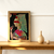Quadro decorativo com uma mulher vestindo roupas coloridas, segurando uma flor, em um ambiente minimalista.