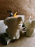 Vela decorativa em formato de fragmento de rosto humano inspirada na escultura de David, com uma das velas acesa