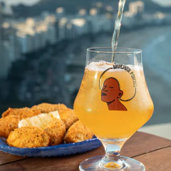 Taça Maritim Mulher Preta com cerveja sendo servida, ao lado de prato com petiscos empanados