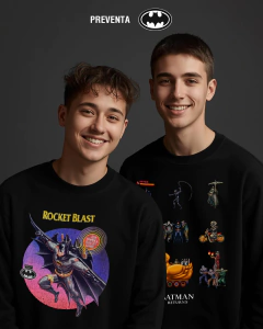 Dos jóvenes sonrientes usando sudaderas negras con diseño de Batman, fondo gris oscuro
