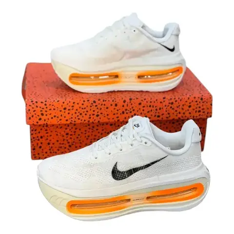 Nike Vomero hombre beige con detalles naranjas sobre su caja Nike
