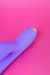 Destaque nos botões que ligam os dois motores independentes do Vibrador Rabbit sobre fundo rosa