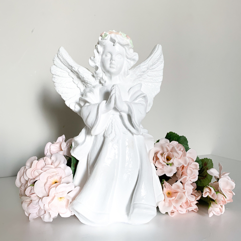 Anjo em pé asa aberta e flores