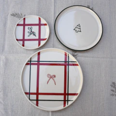 Plato navideño de cerámica artesanal de 22 cm, blanco con líneas rojas y verde inglés y un moño central.