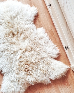 Alfombra de corderito suave y peludo en un ambiente acogedor.