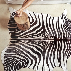 Alfombra de cuero de vaca estampada con diseño de cebra en un entorno moderno.