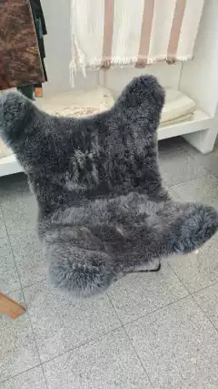 Sillón BKF de cuero de oveja con textura suave y color gris, ubicado en un entorno decorativo moderno.