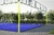 Cancha de pádel Classic con estructura amarilla y superficie azul, rodeada de árboles.