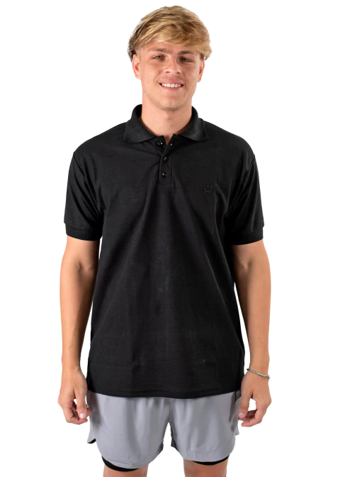 Hombre vistiendo una chomba Wilson Training C negra, ideal para entrenamiento o uso casual