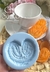 Molde de silicone em formato de biscoito palmier, com um biscoito laranja ao fundo e uma xícara branca.