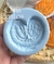 Molde de silicone em formato de biscoito palmier, segurado por uma mão.