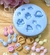 Molde de silicone em forma de miniaturas de Páscoa, com coelhinhos, ovos e cestas coloridas dispostas sobre uma superfície de madeira.