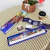 Kit de pintura por números con pinceles y acuarelas sobre una mesa con una canasta y una bebida.