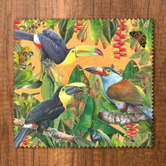 Paño para gafas con ilustraciones de tucanes y flora tropical en colores vibrantes.