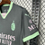 Camisa do AC Milan III 24/25 em cinza escuro com detalhes em verde menta, mostrando o logo do time e patrocinadores.