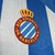 Logotipo do RCD Espanyol de Barcelona em uma camisa azul e branca.
