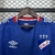 Detalhe da camisa do Nacional Uruguai II 24/25, nas cores azul e vermelha, com logotipo e gola em destaque.