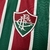 Emblema da camisa Fluminense I 25/26 em verde e grená, destacando o design listrado e o escudo do clube.