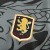 Emblema da camisa Aston Villa Dragão 2025/2026, destacando o leão dourado sobre fundo cinza.