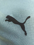 Logotipo da Puma em preto sobre um fundo azul celeste de uma camisa de futebol.
