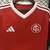 Camisa vermelha e branca do Internacional, modelo 2025/2026, com logo do time e detalhes em branco na gola.