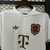 Camisa branca e dourada do Bayern de Munique, com logotipo da Adidas e escudo comemorativo de 125 anos.