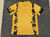 Camisa esportiva amarela com detalhes em preto, vista de trás.