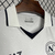Colete esportivo branco com detalhes em azul, destacando a etiqueta EA7 e o logo do Napoli.