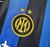 Logotipo do clube de futebol Inter de Milão com duas estrelas acima, em um uniforme listrado preto e azul.