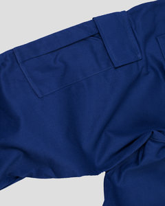 Two Tone Pants é uma calça com corte reto, possui 2 bolsos cargo com pregas nas laterais, 2 bolsos faca frontal e 2 bolsos traseiros com lapela. A peça tem o cós em ribana dupla preta com elástico 4cm, além do cadarço tubular para ajuste do cós.