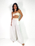 conjunto com calça pantalona com pala e top faixa de crochet na cor natural. O Top possui detalhes frontais em forma de nó.