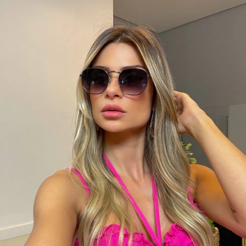 O Óculos de Sol Hexagonal Preto Degradê confeccionado em metal de banho grafite. Lente degradê roxa.