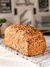 Pan integral orgánico Mix Brot con semillas sobre una mesa de mantel claro.