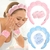 Mulher lavando o rosto usando um kit de acessórios de skincare, incluindo tiara e presilhas nas cores rosa e azul.