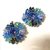 Brincos em crochê fio metal ouro, vidrilhos tchecos em tons de azul e cristal roxo central, 3,5cm x 3,5cm.