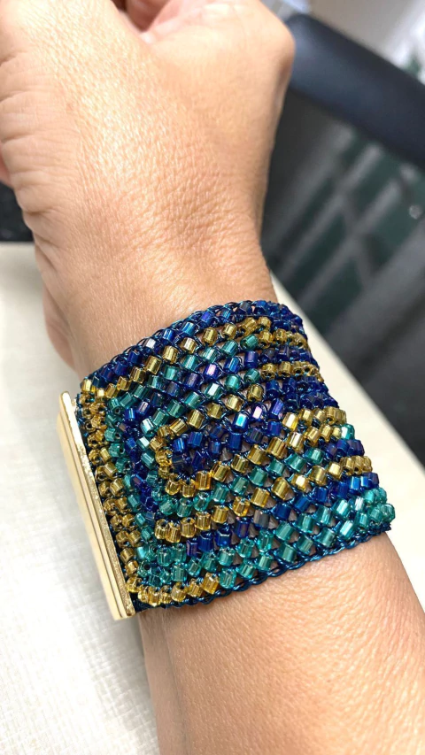 Bracelete, 4cm de largura, em crochê fio metal turquesa, vidrilhos tchecos ouro, verde e azul, fecho magnético.