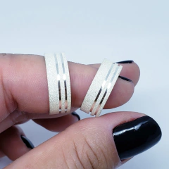 par de alianças em prata diamantada com 2 canais na lateral acompanhado de um anel solitário