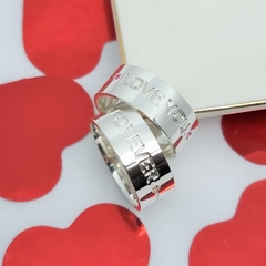 par de alianças em prata com frase gravação externa i love you e outra forever com pedra de zirconia vermelha e champanhe