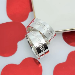 par de alianças em prata com frase gravação externa i love you e outra forever com pedra de zirconia vermelha e champanhe