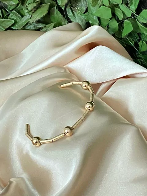 Cod 868; Bracelete dourado escovado, com quatro bolas cheias.