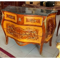 Móvel com design curvado, madeira trabalhada e detalhes em metal, apresentando uma superfície de mármore preto.