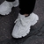 Un par de zapatillas deportivas blancas con detalles en relieve, vistas desde un ángulo bajo.