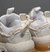 Zapatillas Aglet de color blanco con detalles en beige y cordones rosa, enfocadas en la parte trasera.