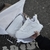 Un par de zapatillas blancas dentro de una caja, con papel de seda alrededor.